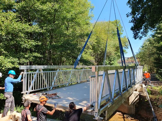 Bei der Sanierung des Radweges im St- Wendeler Land wurde eine fertige Brücke mit einem Autokran eingehoben.